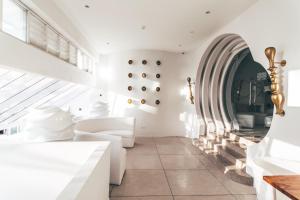 a living room with white furniture and a large window at Dash Resort Langkawi in Pantai Cenang