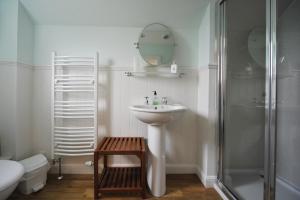 y baño blanco con lavabo y ducha. en Dunallan Guest House, en Grantown-on-Spey