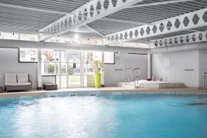 a large swimming pool in a building with a large pool at Langstone Quays Resort, Portsmouth in Portsmouth