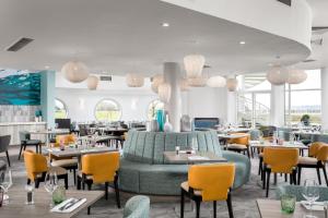 a restaurant with a green couch and tables and chairs at Langstone Quays Resort, Portsmouth in Portsmouth