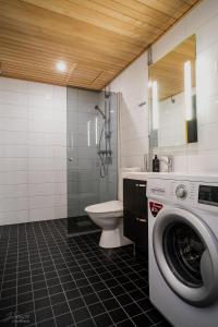 a bathroom with a washing machine and a toilet at Westbay Inn in Vaasa