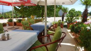 ein Restaurant mit Tischen, Stühlen und einem Sonnenschirm in der Unterkunft Motel Janković in Hrvace