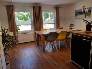 a dining room with a wooden table and chairs at Ferienhaus Strandoase in Oldenburg in Holstein