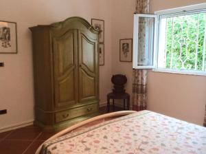 1 dormitorio con armario verde y ventana en Villa Le Palme, en Rosa Marina