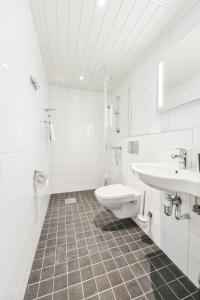 a white bathroom with a sink and a toilet at Hotel Sea Front in Ekenäs