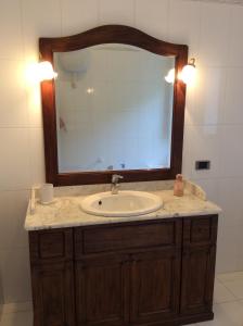 baño con lavabo y espejo grande en Villa Le Palme, en Rosa Marina