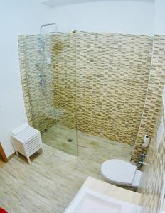 a bathroom with a toilet and a glass shower at Le Amiche in Marina di Ragusa