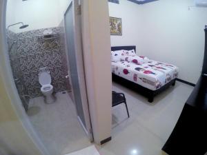 una camera con letto e un bagno con servizi igienici di Amaryllis Guesthouse Syariah a Pacitan