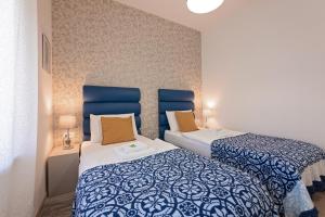 two beds in a room with blue and white at S. Martino Rooms in Pula