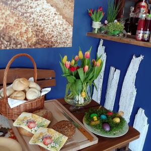 a table with bread and a vase of tulips at Willa Warta in Krynica Morska
