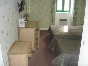 Habitación de hotel con 2 camas, escritorio y mesa en Les Voyageurs en Sizun