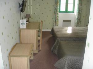 a hotel room with two beds and a desk and a table at Les Voyageurs in Sizun