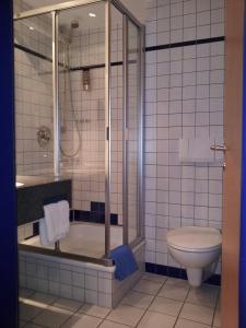 y baño con ducha y aseo. en Hotel Alber, en Leinfelden-Echterdingen