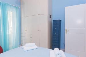 1 dormitorio con cama blanca y pared azul en Palina's comfy home., en Kalamata