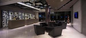 a lobby with black chairs and a wall of glass at Best Western Premier Sukhumvit in Bangkok