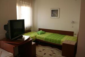 mały pokój z 2 łóżkami i telewizorem w obiekcie Villa Nova w Ochrydzie