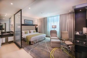a hotel room with a bed and a desk at Royal Tulip Canaan Nairobi in Nairobi