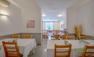 une salle à manger avec des tables et des chaises blanches dans l'établissement Hotel Italia, à Lisbonne