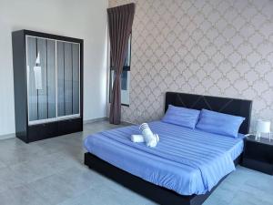 a bedroom with a blue bed with blue pillows at SinggahSini Suite @ Atlantis Residences in Melaka