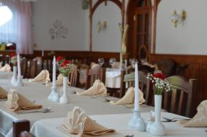 a long table with white vases and flowers on it at Penzion Livada in Kranjska Gora