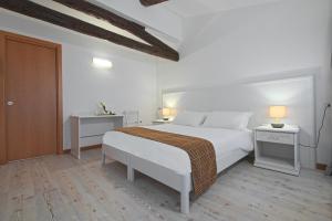 a white bedroom with a bed and two night stands at Palazzetto Canossa in Venice +43 photos
