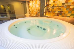 a jacuzzi tub in a bathroom with a glass wall at Star inn Peniche in Peniche