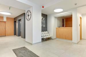 a hallway with a clock on a wall in a building at Platinium Spectrum Apartment in Gdańsk