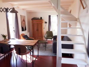 een kamer met een tafel en stoelen en een trap bij Huisje Beukers in Giethoorn
