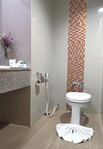 een badkamer met een toilet en een wastafel bij Green World Palace Hotel in Songkhla
