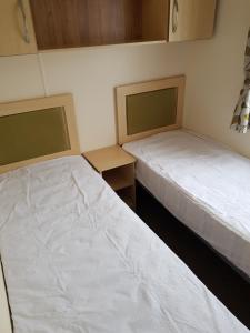 two beds in a small room with two bedsvisor at Caravan Willerby Rio in Looe