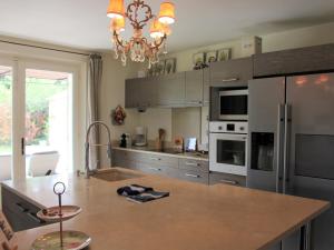 una cocina con electrodomésticos de acero inoxidable y una lámpara de araña en Grandeur Villa in Eygali res with Pool, en Eygalières