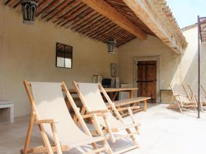 a group of chairs sitting on a patio at Grandeur Villa in Eygali res with Pool in Eygalières