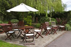 a group of tables and chairs with an umbrella at Haigs Hotel in Coventry