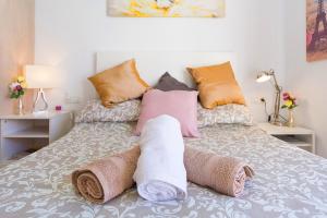 a bed with pillows and towels on it at Studios Nerja Center C in Nerja