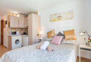 a bedroom with a bed with pillows and a microwave at Studios Nerja Center C in Nerja
