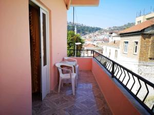 a balcony with a table and a chair on a building at House of Linda 93 in Berat