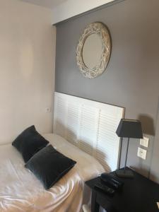 a bedroom with a bed and a mirror and a table at Hôtel Le Mistral in Marseille