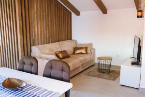 a living room with a couch and a tv at Fonda Apartments in Koper