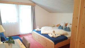 a bedroom with a bed with stuffed animals on it at Pension Lärchenhof in Naturno
