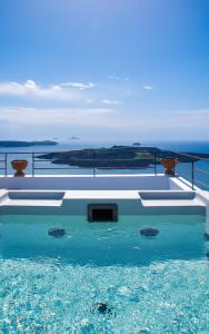 a swimming pool with the ocean in the background at Amelot Art Suites in Fira