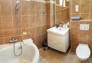 a bathroom with a toilet and a sink and a shower at Gardenia Apartman in Esztergom +68 photos