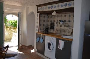 a kitchen with a washing machine and a sink at Les Troglos de l'Echeneau in Vouvray