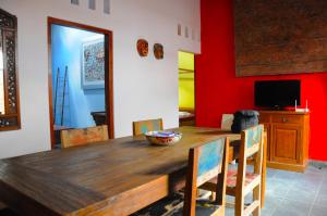 a dining room with a wooden table and red walls at Villa Buddha Malioboro in Yogyakarta