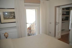 タルクイーニアにあるCamere con vista (Rooms with a view)のベッドルーム1室(ベッド1台付)、バルコニーへのドアが備わります。