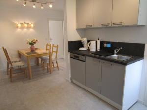 a kitchen with a sink and a table with chairs at Schicke Komfortwohnung zum Wohlfühlen in Merchweiler +6 photos