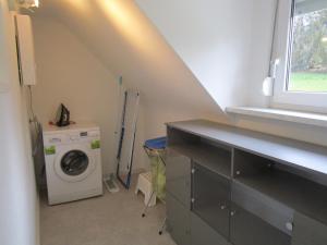 eine Waschküche mit einer Waschmaschine und einem Fenster in der Unterkunft Schicke Komfortwohnung zum Wohlfühlen in Merchweiler