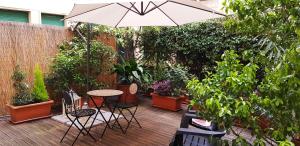 un patio con tavolo, sedie e piante di Bologna Central Apartment a Bologna