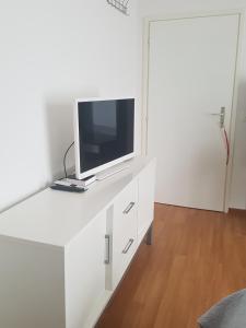 białe biurko z telewizorem na górze w obiekcie Homestay Dodo w mieście Lugano