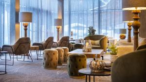 eine Hotellobby mit Stühlen, Tischen und Fenstern in der Unterkunft Travel Charme Fürstenhaus am Achensee in Pertisau