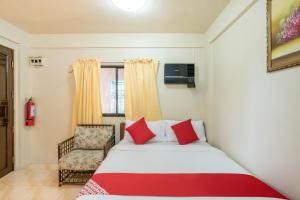 1 dormitorio con 1 cama y 1 silla en Conrado's Apartelle en Manila